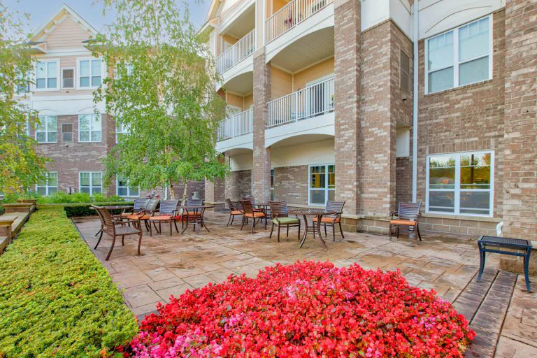 Outdoor patio with vibrant flowers and seating area.
