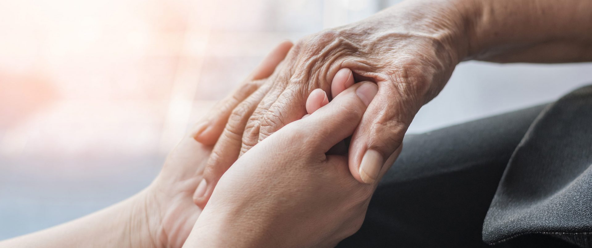 A close-up of two hands holding each other.