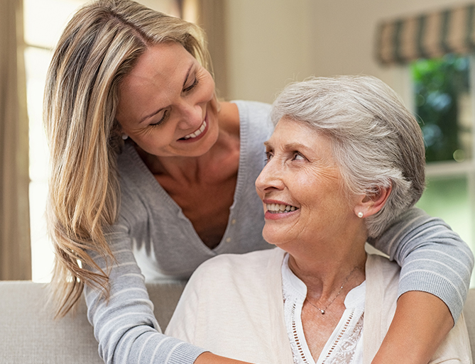 Smiling interaction between caregiver and elderly resident.