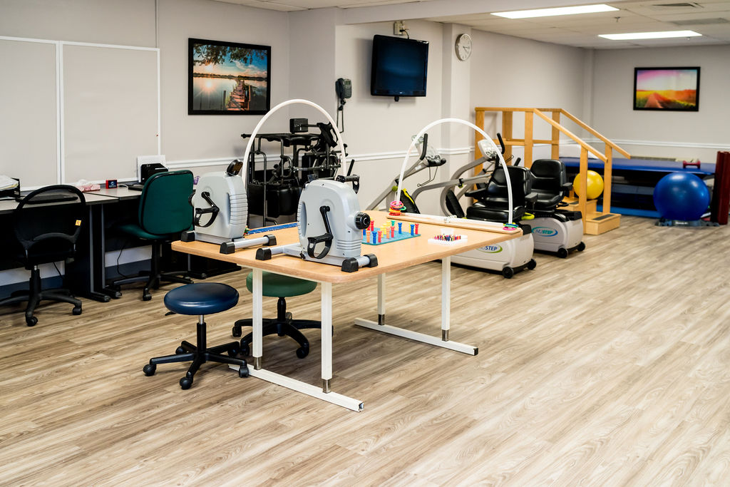 Rehabilitation exercise area with equipment and seating.