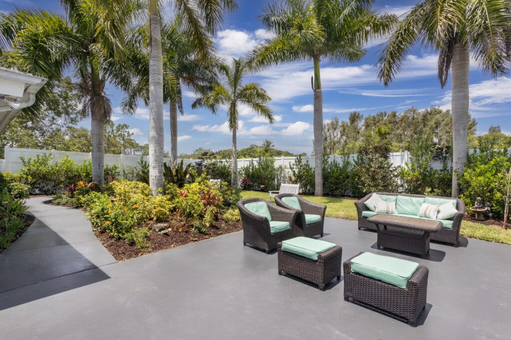Outdoor seating area with palm trees and landscaped garden