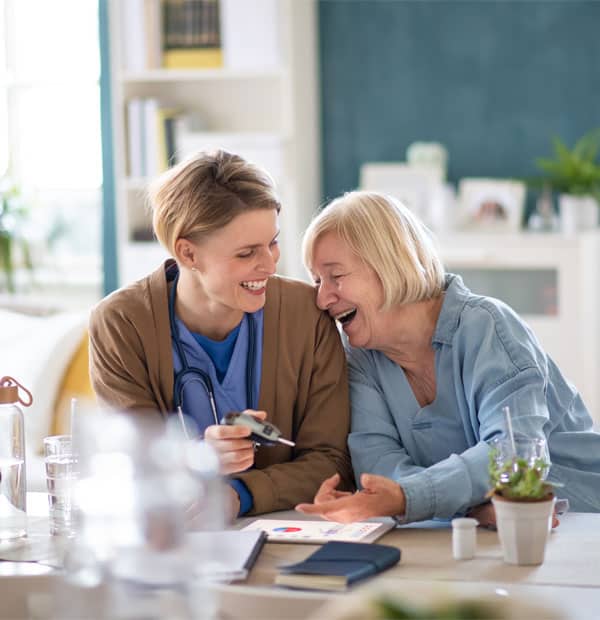 Caregiver and resident sharing a joyful moment indoors