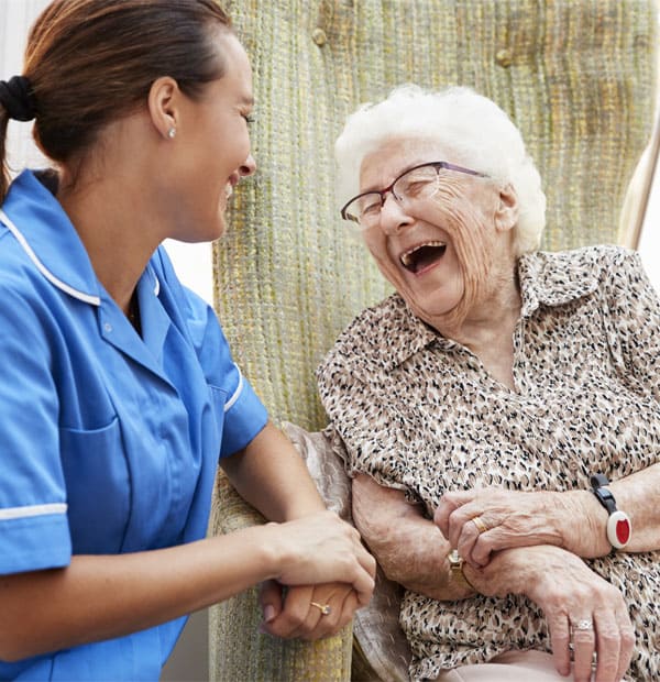 Caregiver laughing with a senior resident