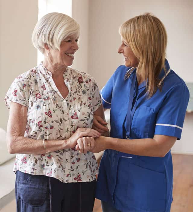 Staff member interacting with a resident in a bright interior