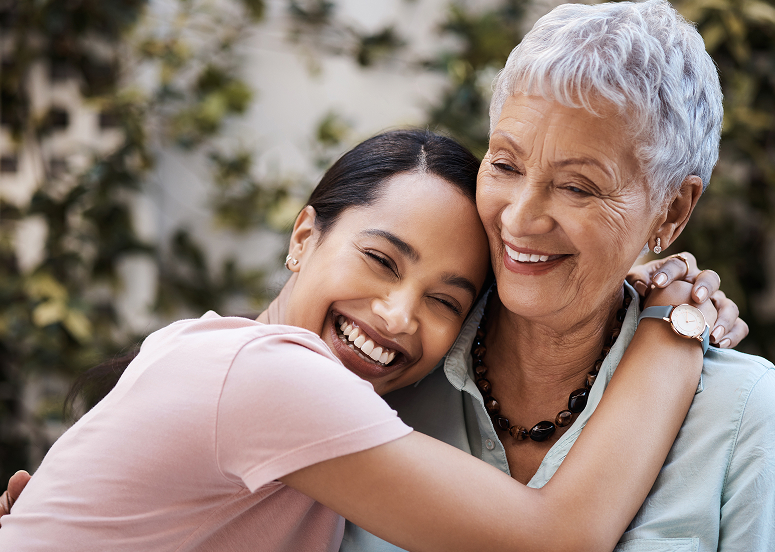 A caregiver and resident embracing and smiling