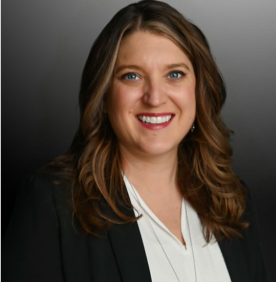 Professional portrait of a smiling woman in a blazer