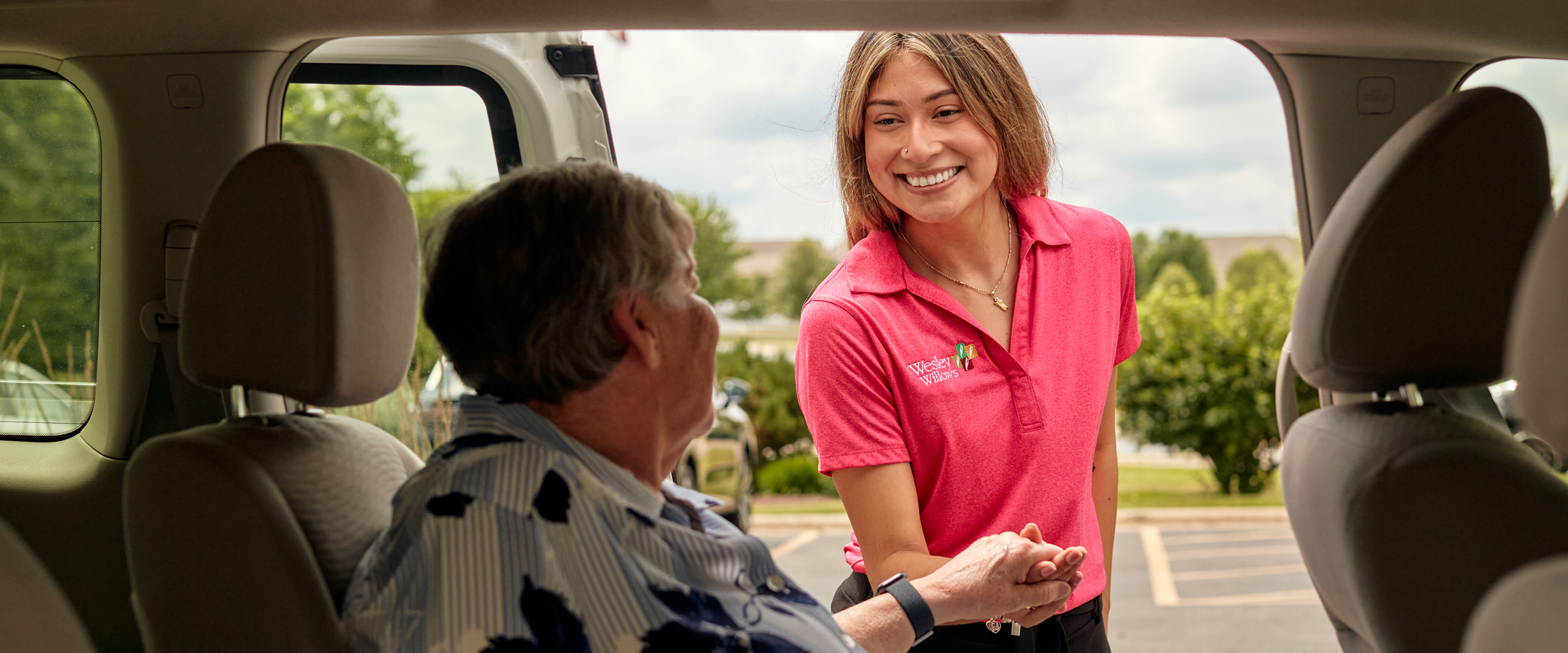 A staff member assisting a resident in a vehicle