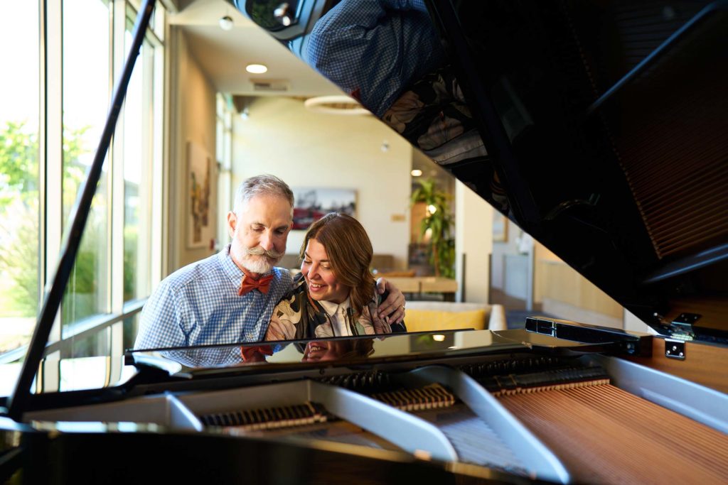 Residents enjoying music together at a grand piano
