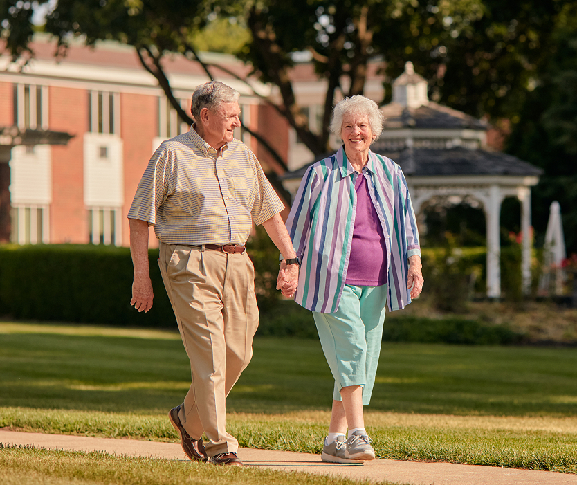 Two residents walking hand-in-hand in a garden
