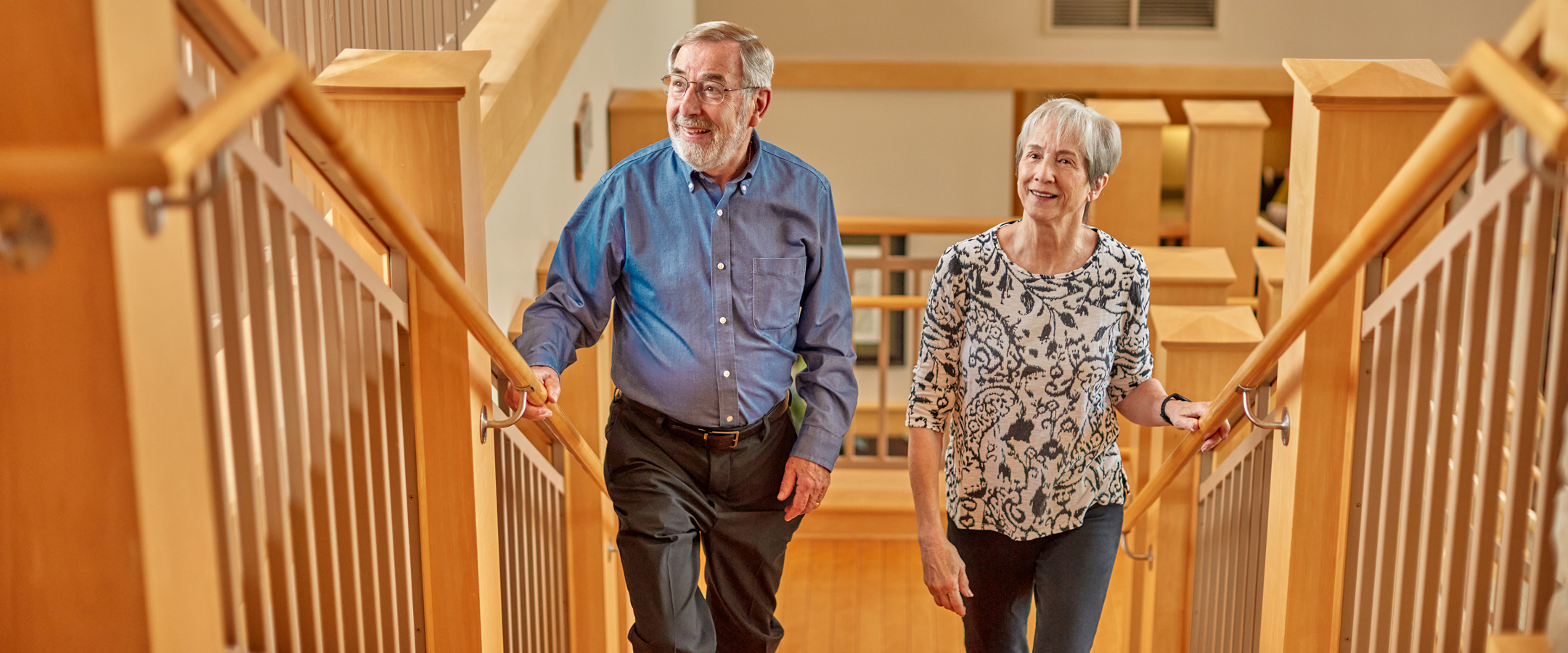 Two smiling residents walking up the stairs