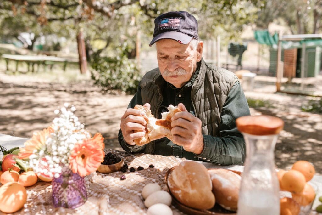 A resident enjoying a meal outdoors in a garden setting.