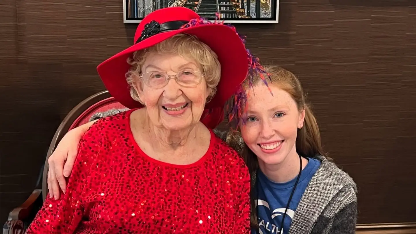 Senior resident with staff member in an activity room