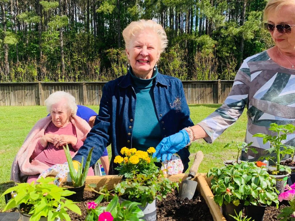 Residents gardening outdoors with flowers and plants