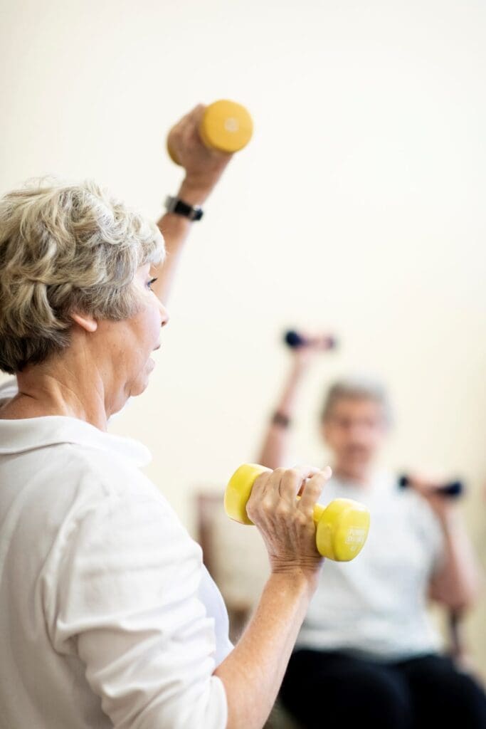 Senior residents participating in a fitness class with dumbbells