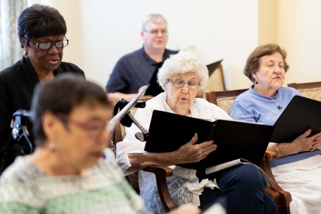 Residents participating in a singing activity in a common area