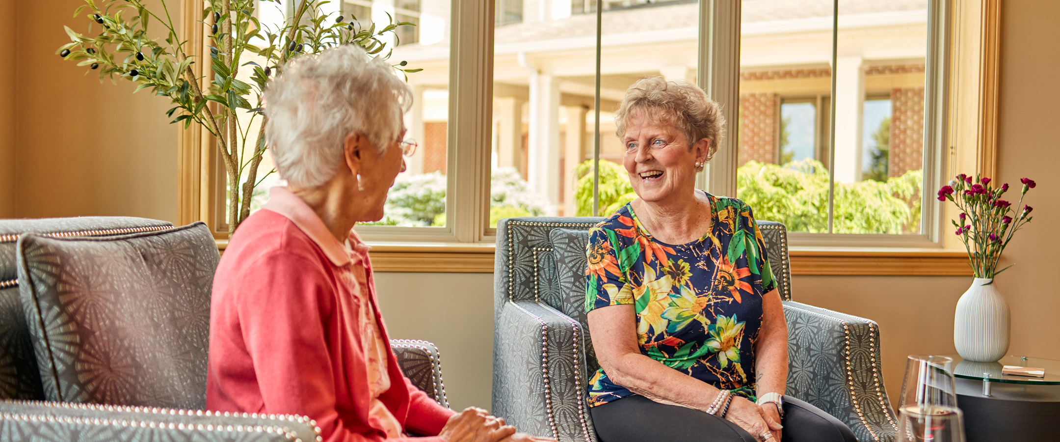 Two residents chatting in a cozy common area