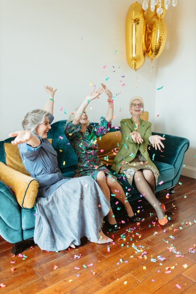 Three women celebrating indoors with confetti