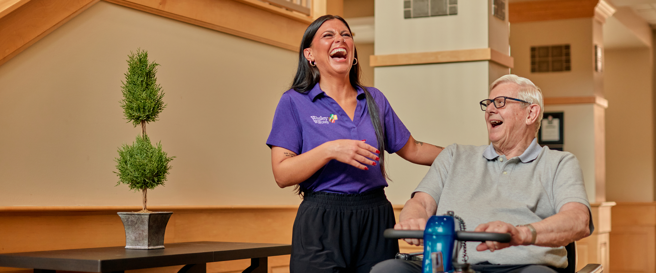 Staff member laughing with a resident in a common area