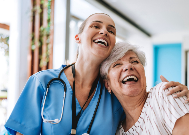Senior resident and caregiver sharing a joyful moment