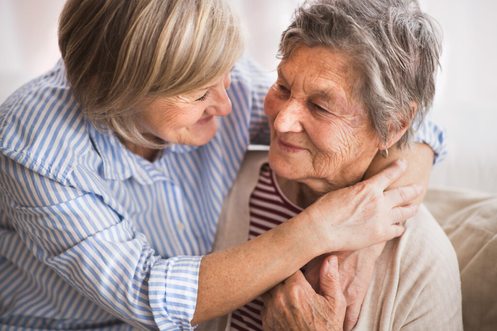 A caregiver and an elderly woman sharing a warm moment