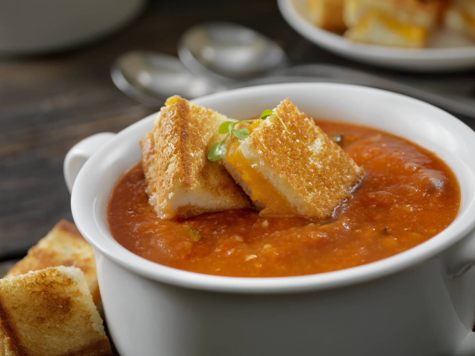 A bowl of tomato soup with grilled cheese croutons