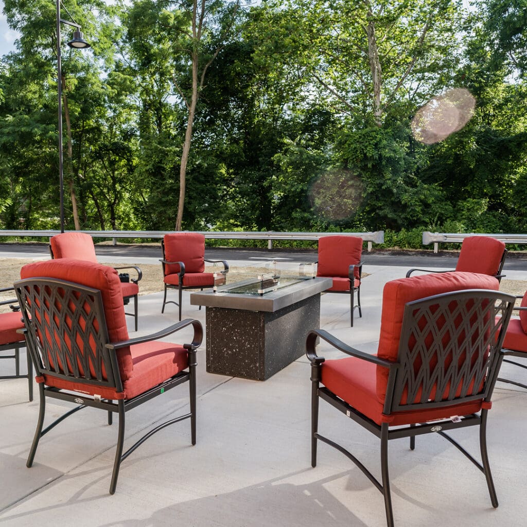 Outdoor seating area with red chairs and a fire pit