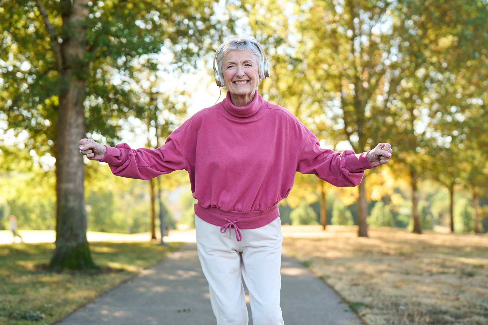 Senior woman walking happily in a park