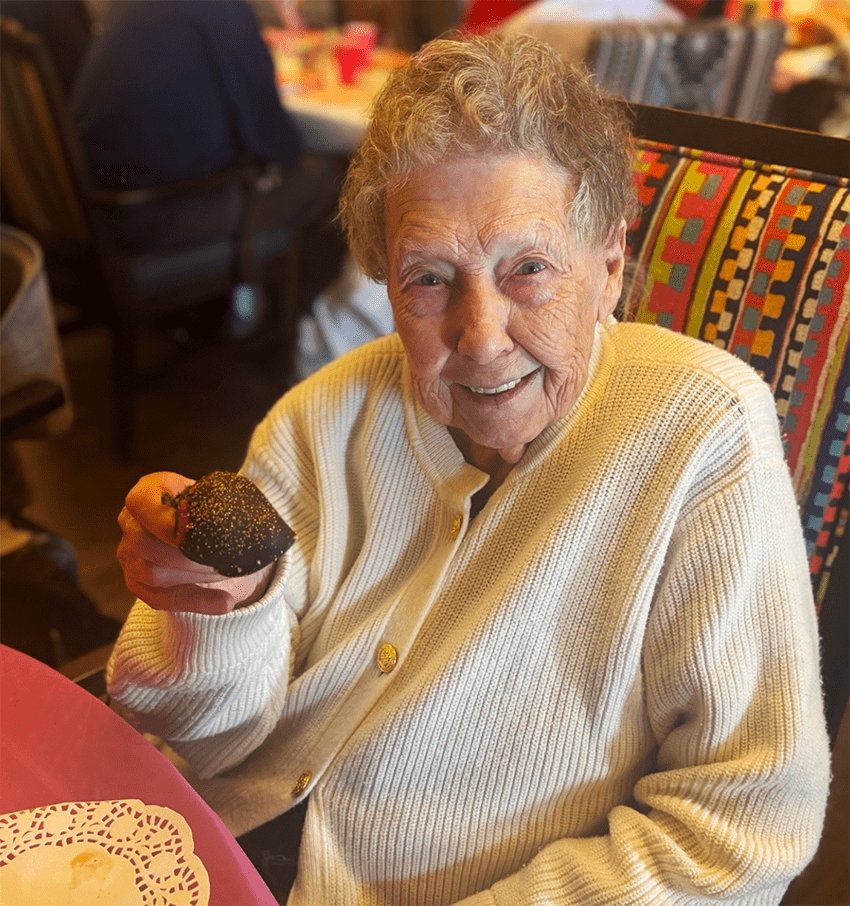 Resident smiling while holding a dessert