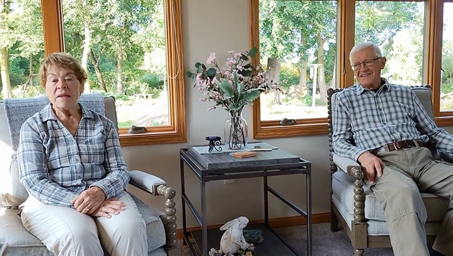 Two residents relaxing in a common area with large windows