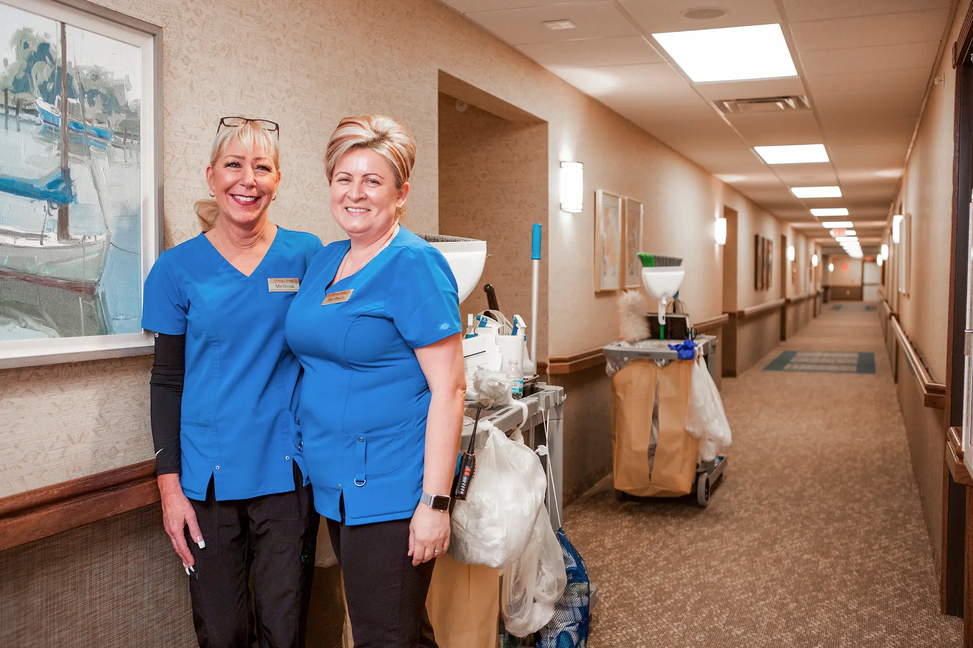 Staff members smiling in a facility hallway