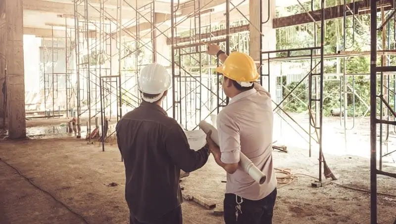 Two construction workers discussing plans in a building site