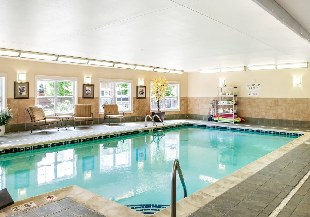 Indoor pool area with seating and windows
