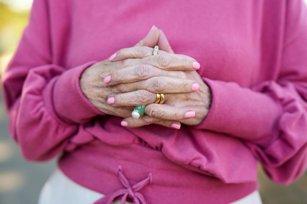 Close-up of hands with rings and pink nails