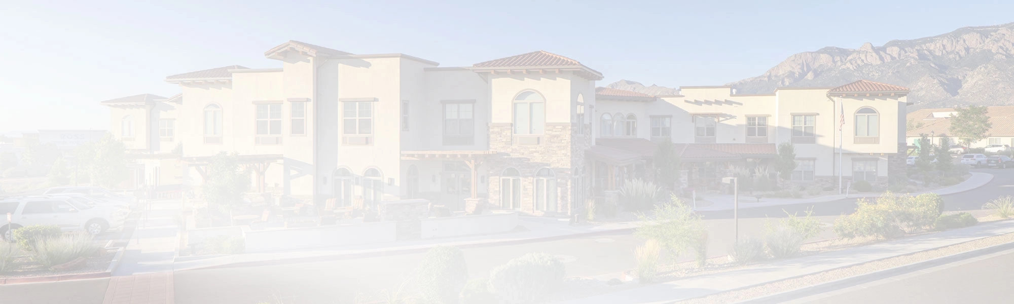 Exterior view of a senior living facility surrounded by mountains