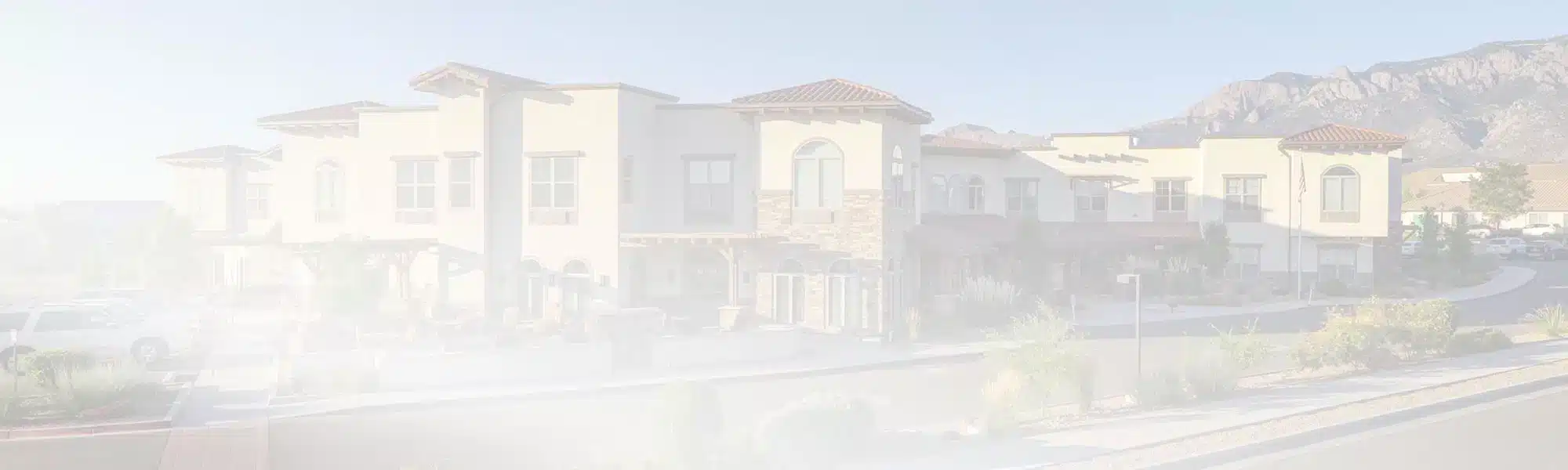 Exterior view of a senior living facility with mountains