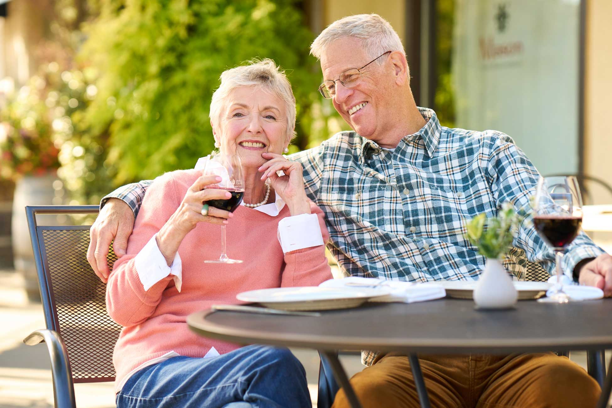 An older couple enjoying wine outdoors