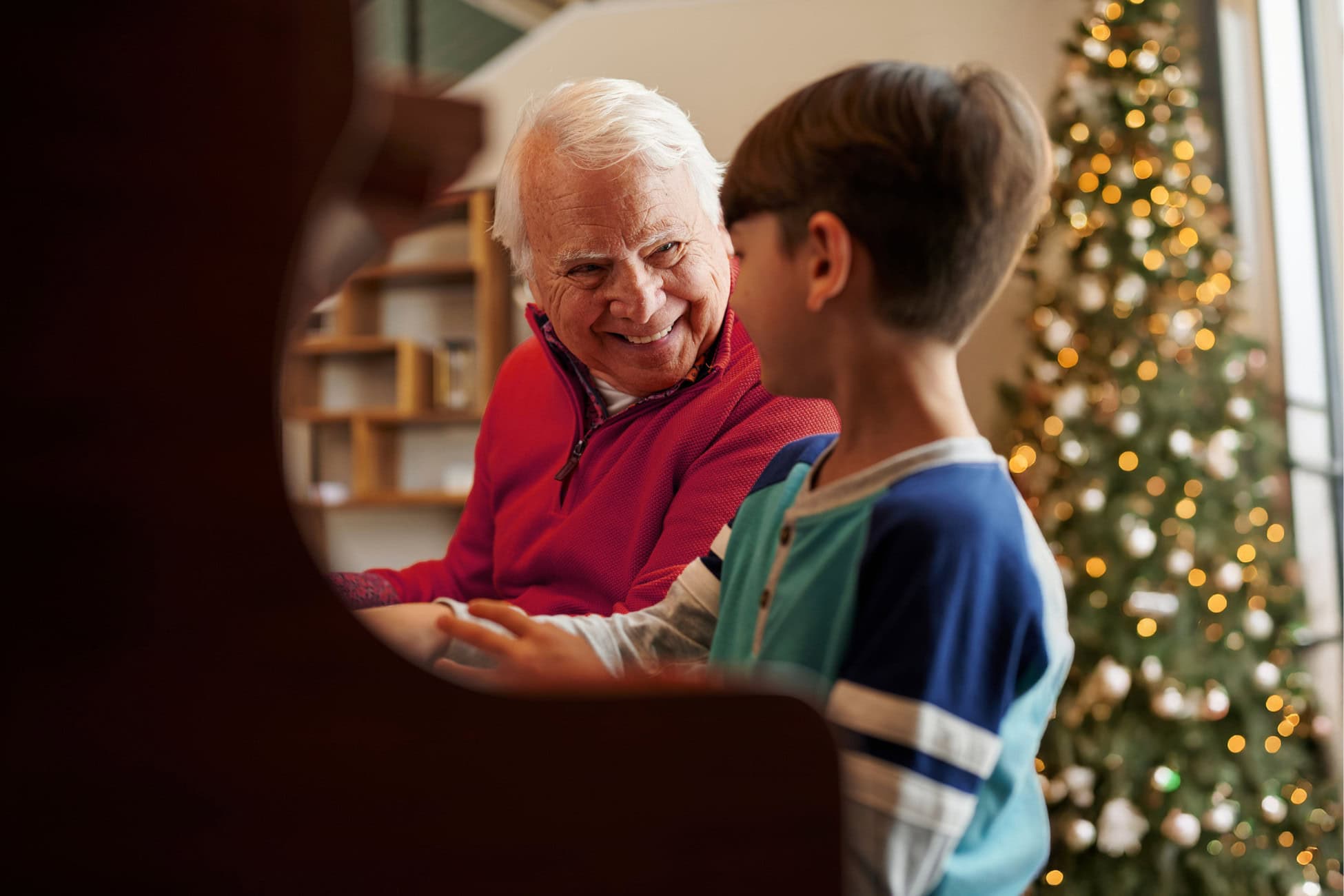 Senior resident smiling and interacting with a young boy indoors