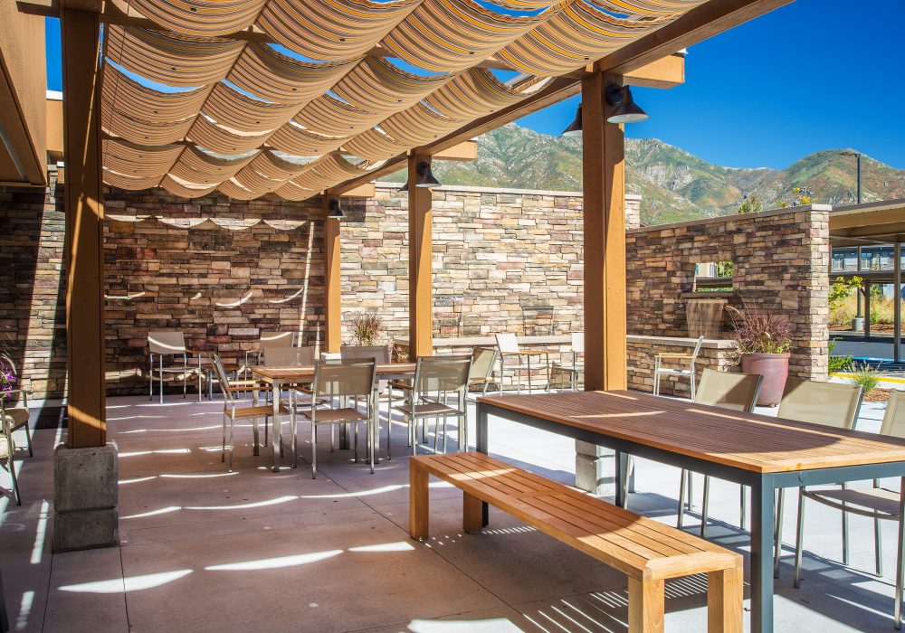 Outdoor seating area with stone walls and mountains in the background