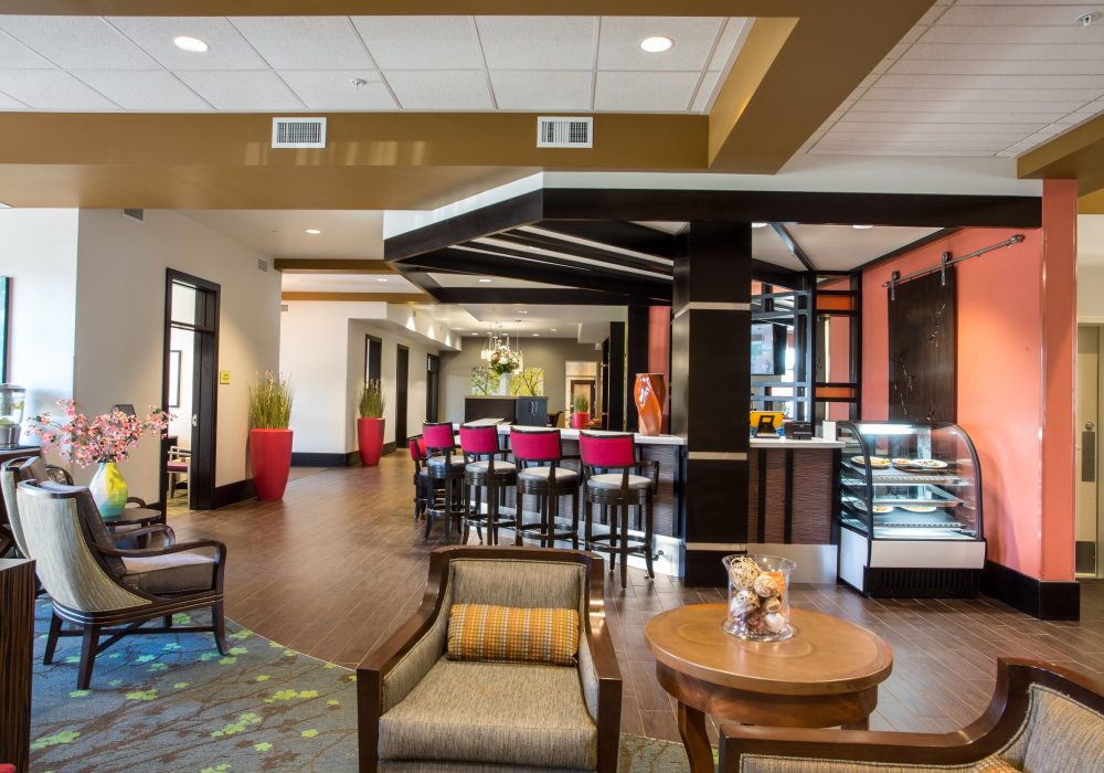 Interior view of a stylish common area with seating and a dessert display