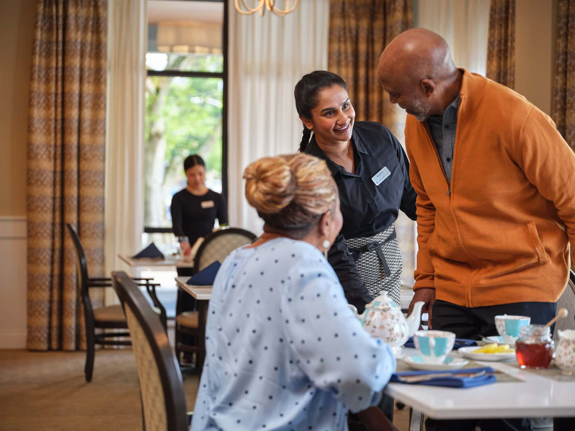 Residents enjoying food service in a lively dining area