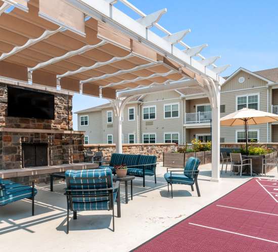 Outdoor seating area with shaded pergola and fireplace