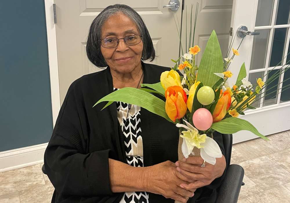 Resident holding a bouquet of flowers in common area