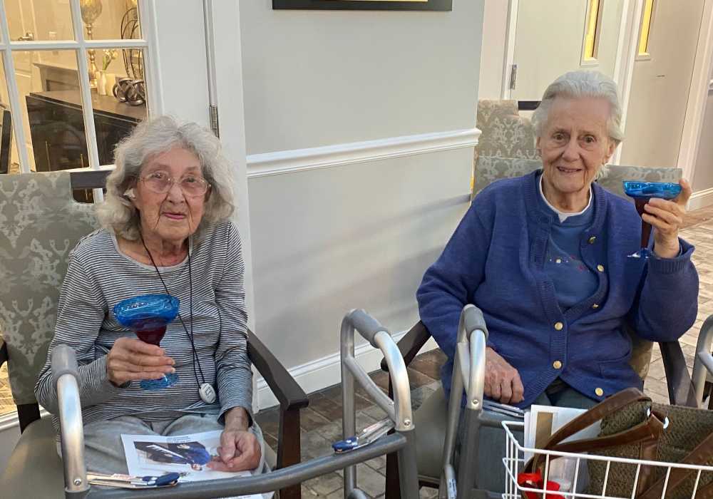 Two residents celebrating with drinks in the common area