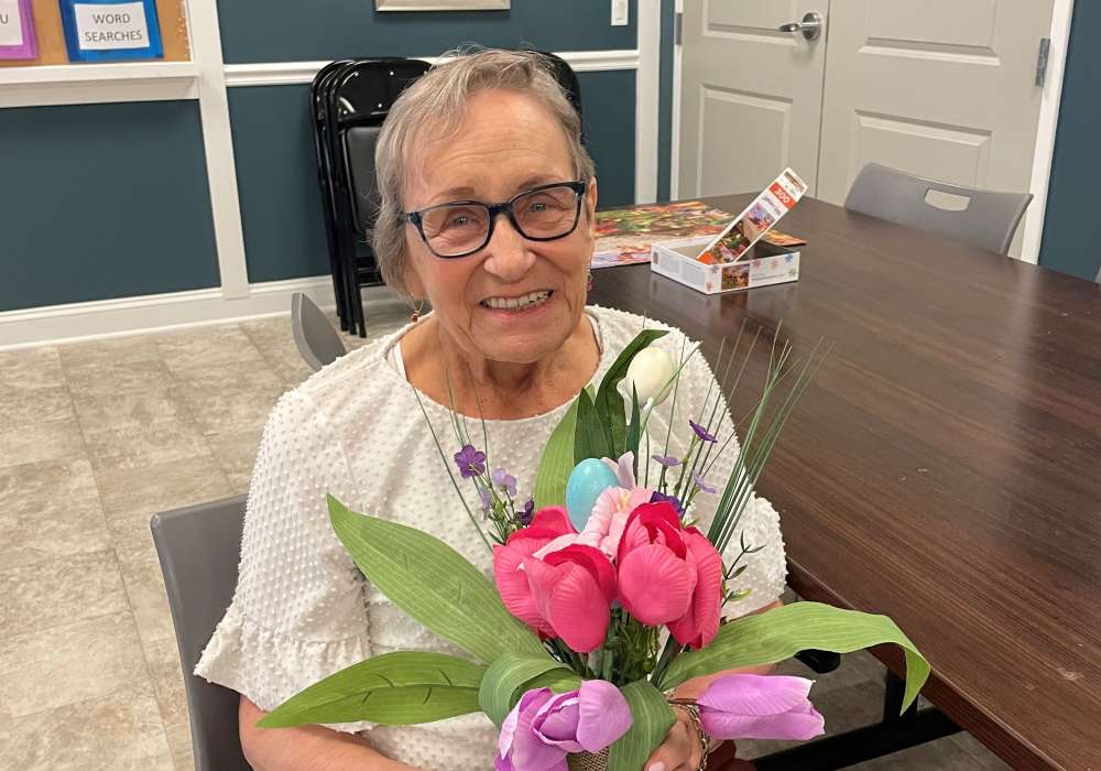 A resident holding a bouquet of flowers in a common area