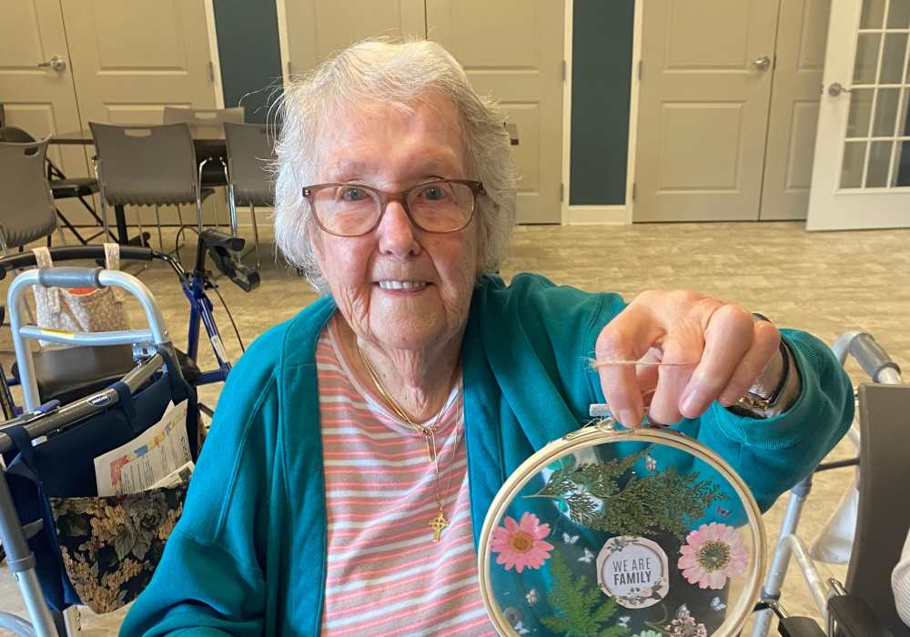 Resident showcasing a craft project in the activity room
