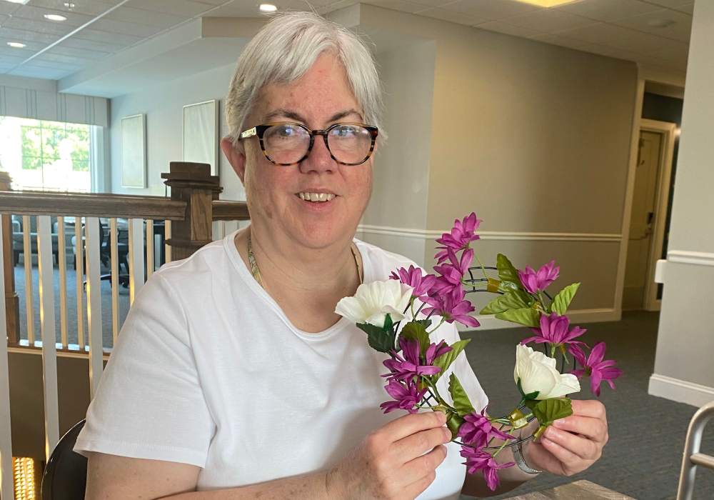 A resident creating floral crafts in a common area