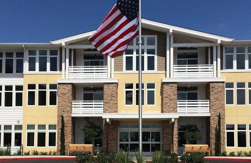 Exterior view of Merrill Gardens building with flag