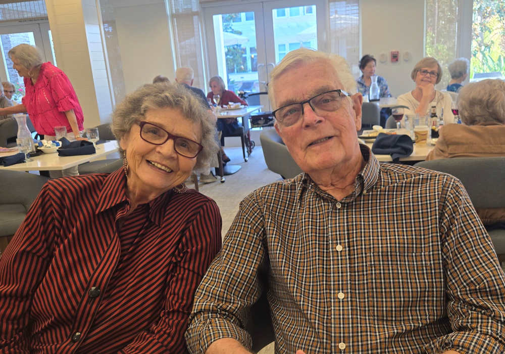 Two smiling residents enjoying time together in a common area