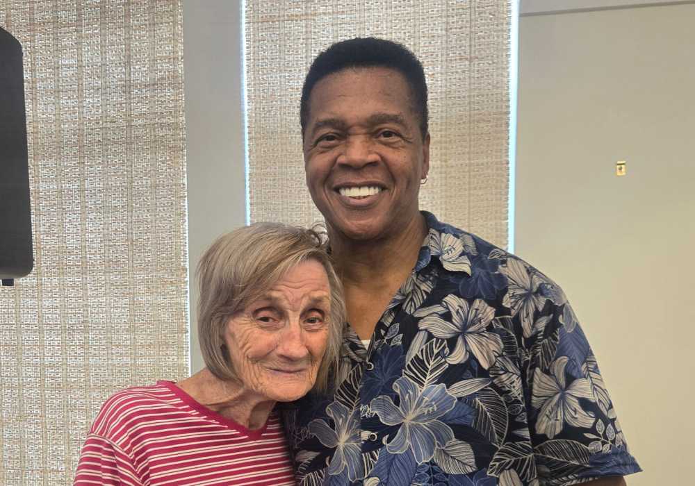A resident and staff member smiling together