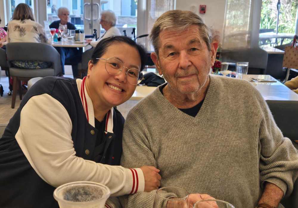 A staff member and a resident smiling together in a common area